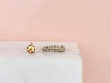a pair of gold rings sitting on top of a white marble block