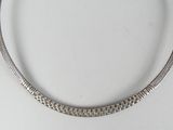 an antique silver necklace on a white surface with a white background