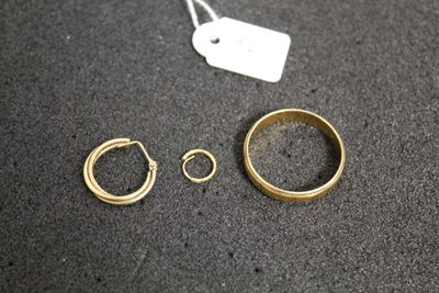 two gold rings and a ring with a price tag on a table