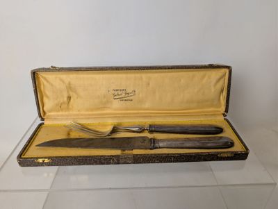 a knife and a fork in a case on a table