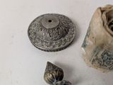 a small metal object on the table next to a small metal object