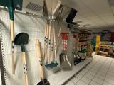 many shovels hanging on the wall in the store