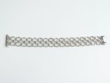 a close up of a silver chain bracelet on a white surface