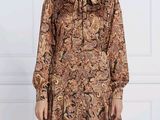 une femme portant une robe marron à motifs cachemire à manches longues