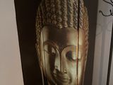 une photo d'une statue de Bouddha accrochée au mur à côté d'une table
