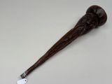 a wooden stick with a handle on a white surface