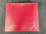 an old red book sitting on top of a black cloth