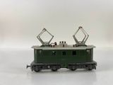 a green train car that is sitting on a white surface