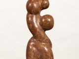 sculpture of a woman holding a child on her back on a white surface