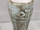 un vase orné d'un visage, exposé