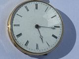 une montre de poche en or avec des chiffres romains sur le cadran