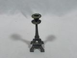 a small metal candle holder on a white surface