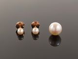 a pair of pearl and gold earrings on a black surface