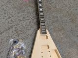 a wooden guitar that is laying on the ground