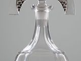 a clear glass decanter with a silver decoration on it