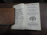 un livre ouvert posé sur une table, avec une couverture en cuir
