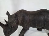 a statue of a rhino standing on a white surface
