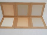 three boxes of makeup are open on a white surface