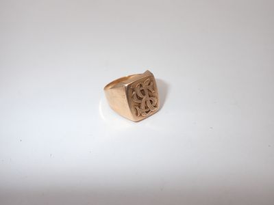 a close up of a gold signet ring on a white surface