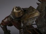 a statue of a man riding a horse with a shield on his back