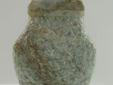 une statue représentant un homme assis sur un vase