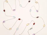 a close up of a necklace with various colored stones on it