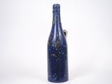 une bouteille bleue décorée de confettis