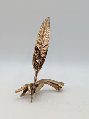 une figurine en laiton représentant une feuille sur une branche