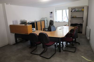 une longue table avec des chaises dans une pièce remplie de livres