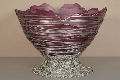 un saladier en verre violet posé sur une table