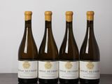 quatre bouteilles de vin sont alignées sur une table