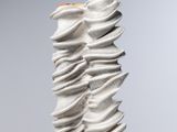 un gros plan d'une sculpture posée sur une table, sur fond gris