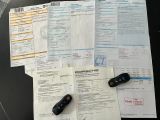 papers and remote controls on a table next to a cell phone
