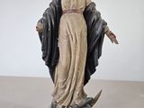 une statue représentant une femme tenant une épée, debout sur un rocher