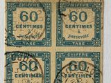four old postage stamps on a piece of paper with a string