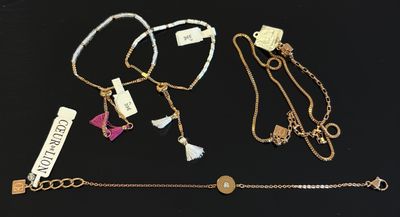 quatre colliers et bracelets différents posés sur un fond noir