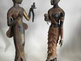 deux statues représentant une femme tenant un oiseau et un oiseau dans la main