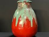 un vase rouge et vert posé sur une table