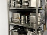 many pots and pans on the shelves in the kitchen