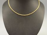 a gold chain necklace on a mannequin neck