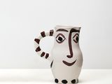 two vases that have faces on them on a table