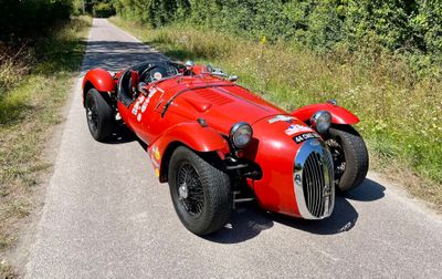 une voiture de course rouge garée sur le bord de la route