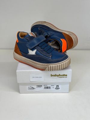 des chaussures de bébé bleues et orange pour garçon posées sur une boîte blanche