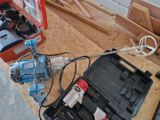 a box with tools on the floor next to a drill