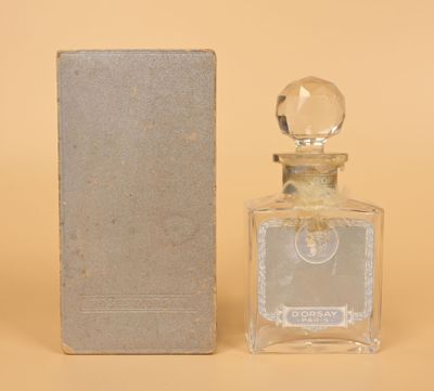 l'image d'un flacon de parfum posé à côté d'une boîte