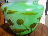 a green vase sitting on top of a wooden table