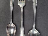 three spoons and a fork sitting on a table