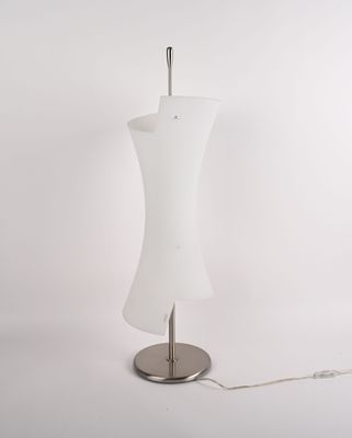 une lampe blanche posée sur un pied en métal