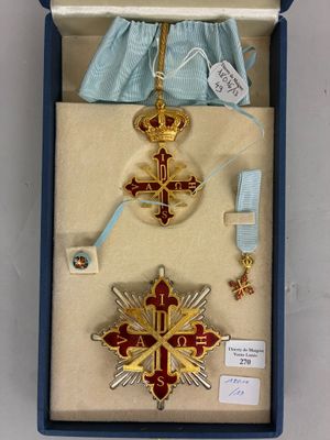 une boîte contenant une croix, une médaille, un ruban et d'autres objets