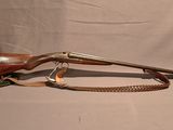 un vieux fusil avec un canon en bois et un étui en cuir